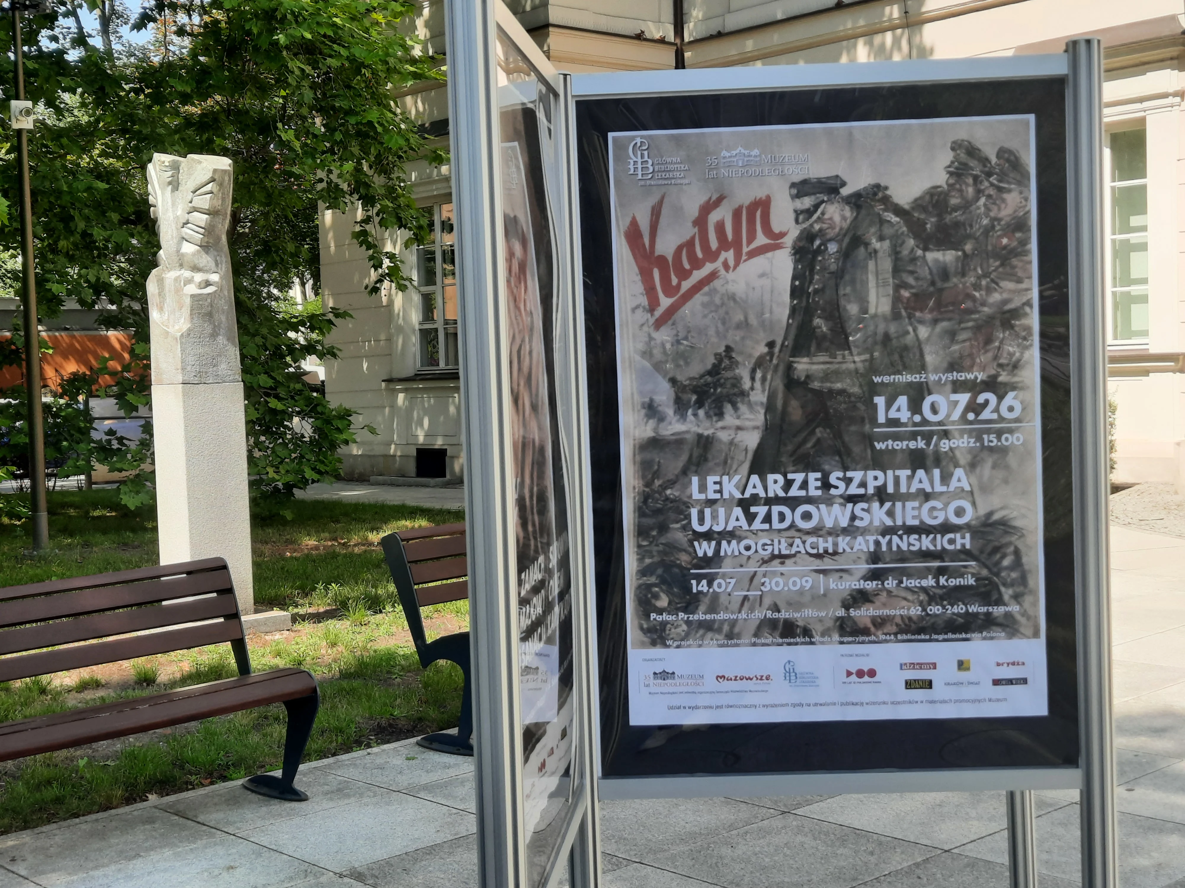 Plakat wystawy przed wejściem do budynku.