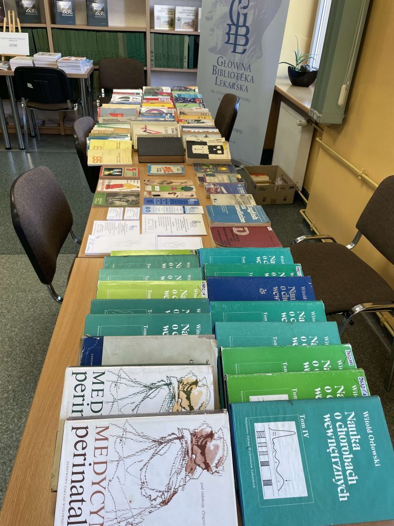Stół pełen literatury medycznej i naukowej na stoisku Głównej Biblioteki Lekarskiej